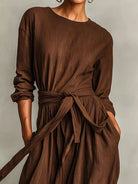 NEWYORKLISTED STYLE COLLECTION: Brown dress with a belt on a plain background