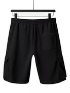 NEWYORKLISTED ATLAS MEN'S COLLECTION: Black shorts on a hanger against a white background