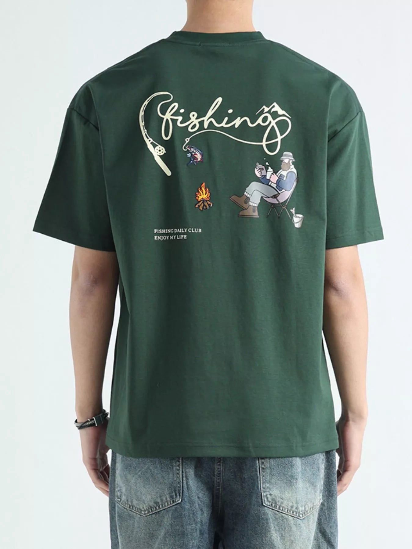 NEWYORKLISTED ATLAS MEN'S COLLECTION: Green t-shirt with fishing-themed design on the back, worn by a person.