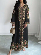 NEWYORKLISTED STYLE COLLECTION: Woman wearing a black dress with floral embroidery in a minimal indoor setting