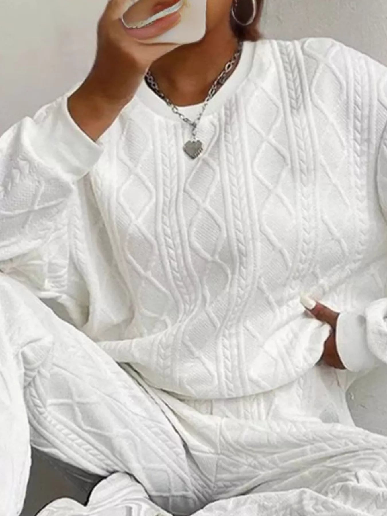 NEWYORKLISTED COMFORT COLLECTION: White cable knit sweater worn by a person against a neutral background