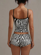 NEWYORKLISTED INTIMATE APPAREL COLLECTION: Person wearing a zebra print two-piece set against a neutral background