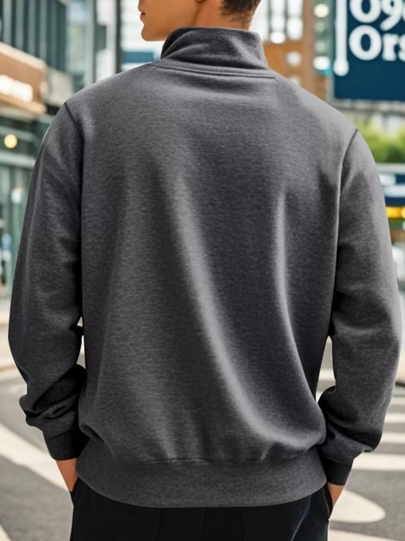 NEWYORKLISTED ATLAS MEN'S COLLECTION: Person wearing a gray jacket with a blurred urban background