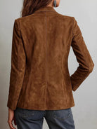 NEWYORKLISTED STYLE COLLECTION: A woman shown from the back wearing a brown suede blazer and blue jeans against a plain light gray background.