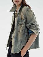 NEWYORKLISTED STYLE COLLECTION: Person wearing a denim jacket with embroidered designs on a white background