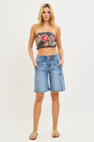 NEWYORKLISTED STYLE COLLECTION: Woman wearing a floral bandeau top and denim shorts on a white background