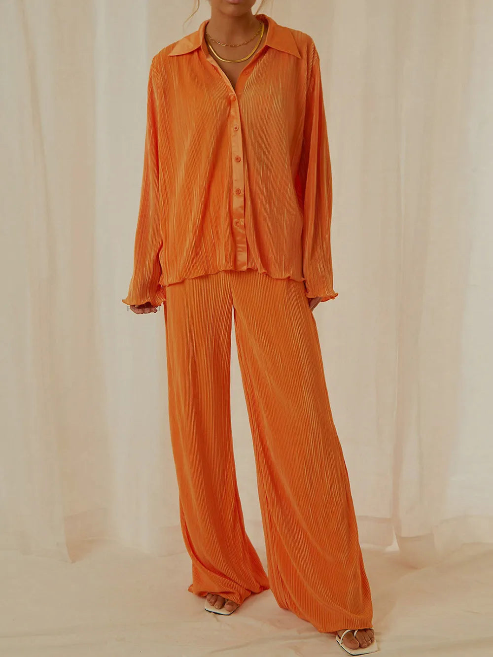 NEWYORKLISTED Intimate Apparel Collection: Orange outfit with a shirt and pants on a neutral background