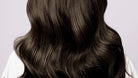 NEWYORKLISTED COSMETIC COLLECTION: Grow Hair Oil, Close-up of long, dark brown hair on a light gray background