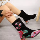 NEWYORKLISTED Shoe Collection: Black embroidered ankle boots with floral designs worn by a person.