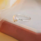 Silver ring with a pearl on a soft fabric background