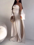 NEWYORKLISTED COMFORT COLLECTION: Woman wearing a white strapless dress with long sleeves against a plain background