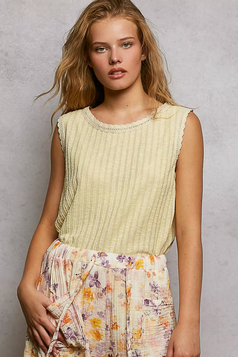 NEWYORKLISTED STYLE COLLECTION: Woman wearing a light green sleeveless top and floral skirt against a gray background