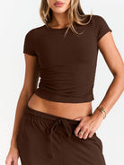 Person wearing a brown crop top and pants on a white background