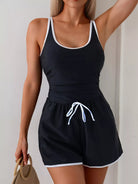 NEWYORKLISTED STYLE COLLECTION: Woman wearing a black tank top and shorts set with white drawstring against a light background