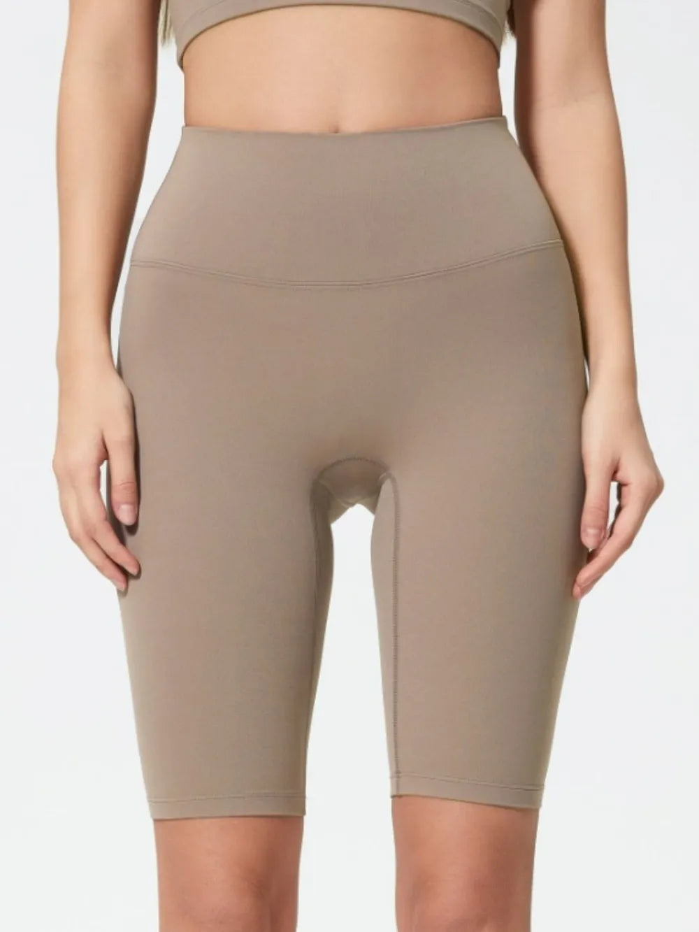 Beige high-waisted leggings worn by a person on a white background