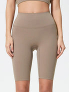Beige high-waisted leggings worn by a person on a white background