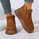 NEWYORKLISTED SHOE COLLECTION: A pair of women's brown suede ankle boots with plush faux-fur lining, shown on a model wearing blue jeans against a clean white background.