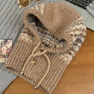 NEWYORKLISTED STYLE COLLECTION: Drawstring Knitted Winter Hat – Cozy, Chic & Cold-Weather Ready: Brown knitted sweater with a hood on a wooden surface