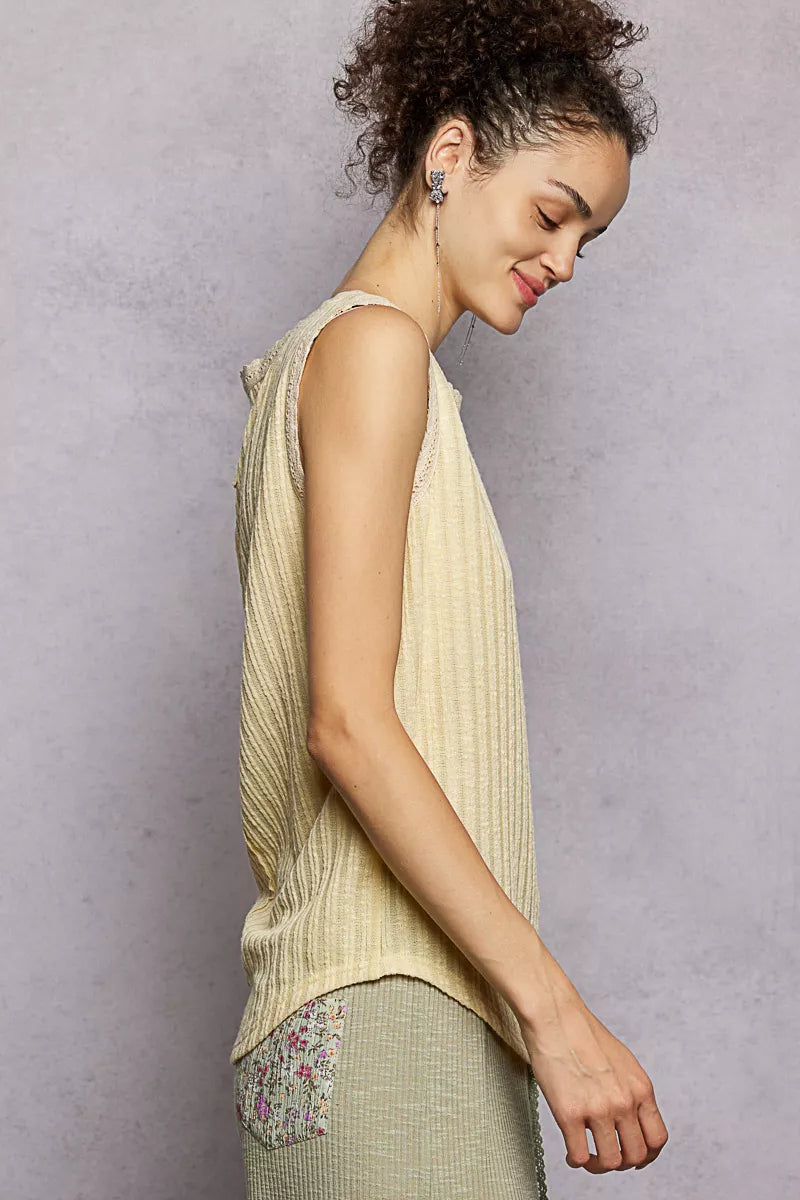 NEWYORKLISTED STYLE COLLECTION: Woman wearing a light-colored sleeveless top with floral details on a plain background
