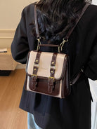 NEWYORKLISTED STYLE COLLECTION: Person wearing a white and brown leather bag over their shoulder indoors.