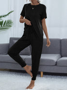 NEWYORKLISTED Intimate Apparel: Person wearing a black outfit standing in front of a gray sofa.