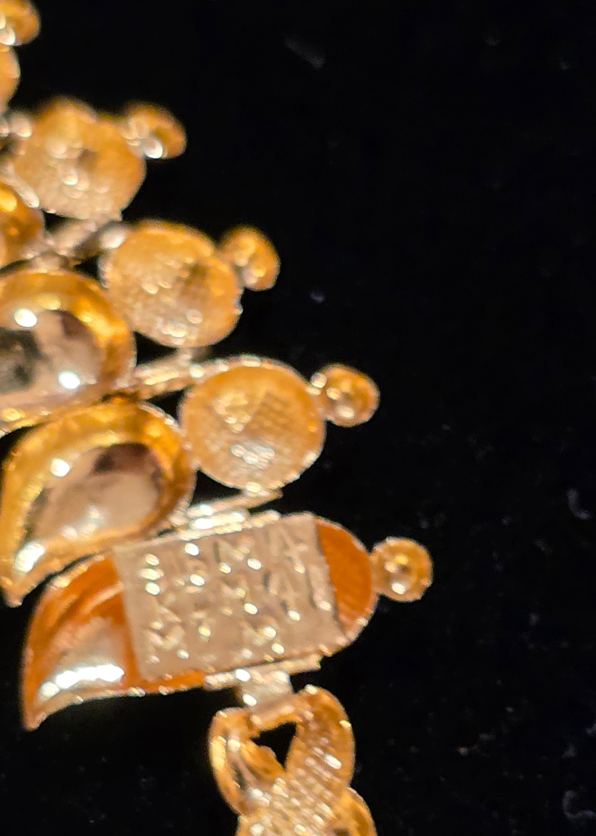 NEWYORKLISTED Valentine's Day Gifts: 22k gold necklace with decorative elements on a black background 