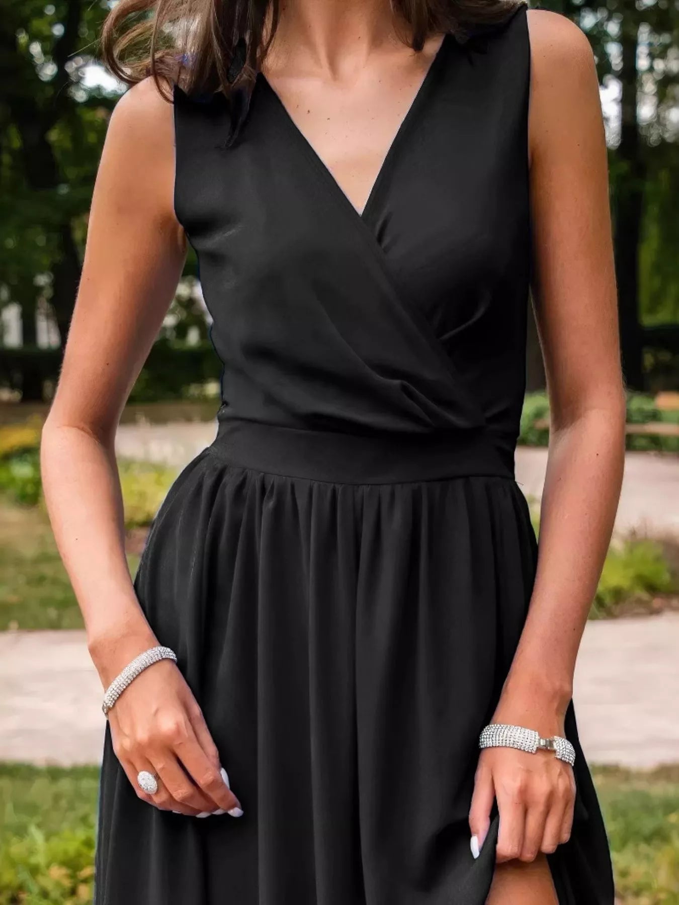 NEWYORKLISTED STYLE COLLECTION: Person wearing a black dress with a blurred outdoor background