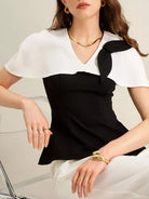 NEWYORKLISTED STYLE COLLECTION: Woman wearing a black and white top with a bow detail on a light background