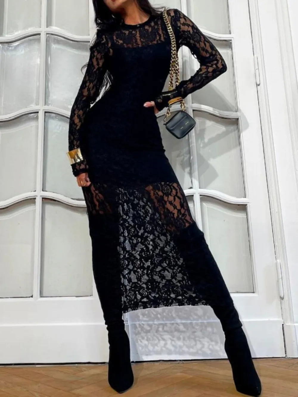 NEWYORKLISTED Valentine's Day Specials: Fashion model wearing a black lace dress with long sleeves and a matching bag against a white wall.