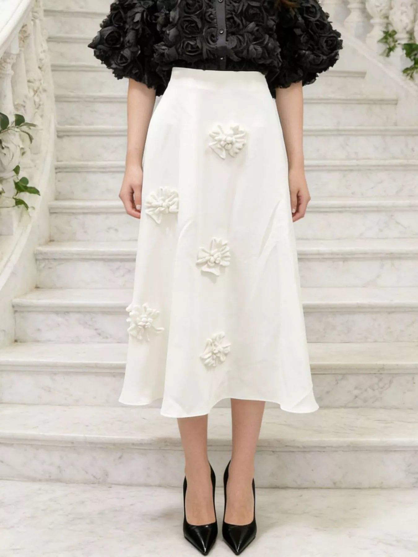 NEWYORKLISTED STYLE COLLECTION: Person wearing a white floral skirt on a marble staircase