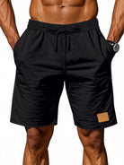 NEWYORKLISTED ATLAS MEN'S COLLECTION: Black shorts with a drawstring on a plain background