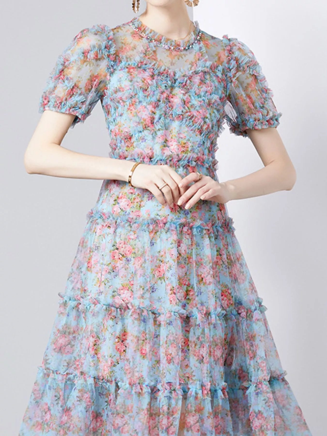 NEWYORKLISTED STYLE COLLECTION: Floral dress with short sleeves and a tiered skirt on a plain background