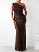 Woman wearing a brown one-shoulder dress against a white background