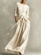 NEWYORKLISTED STYLE COLLECTION: Woman wearing a long, flowing white dress against a neutral background
