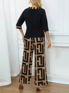 NEWYORKLISTED: Woman wearing a black top and patterned pants standing in a room with white curtains.