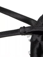 NEWYORKLISTED STYLE COLLECTION: Close-up of a black satin garment with straps on a white background