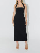  NEWYORKLISTED STYLE COLLECTION: Black halter neck dress worn by a person on a white background