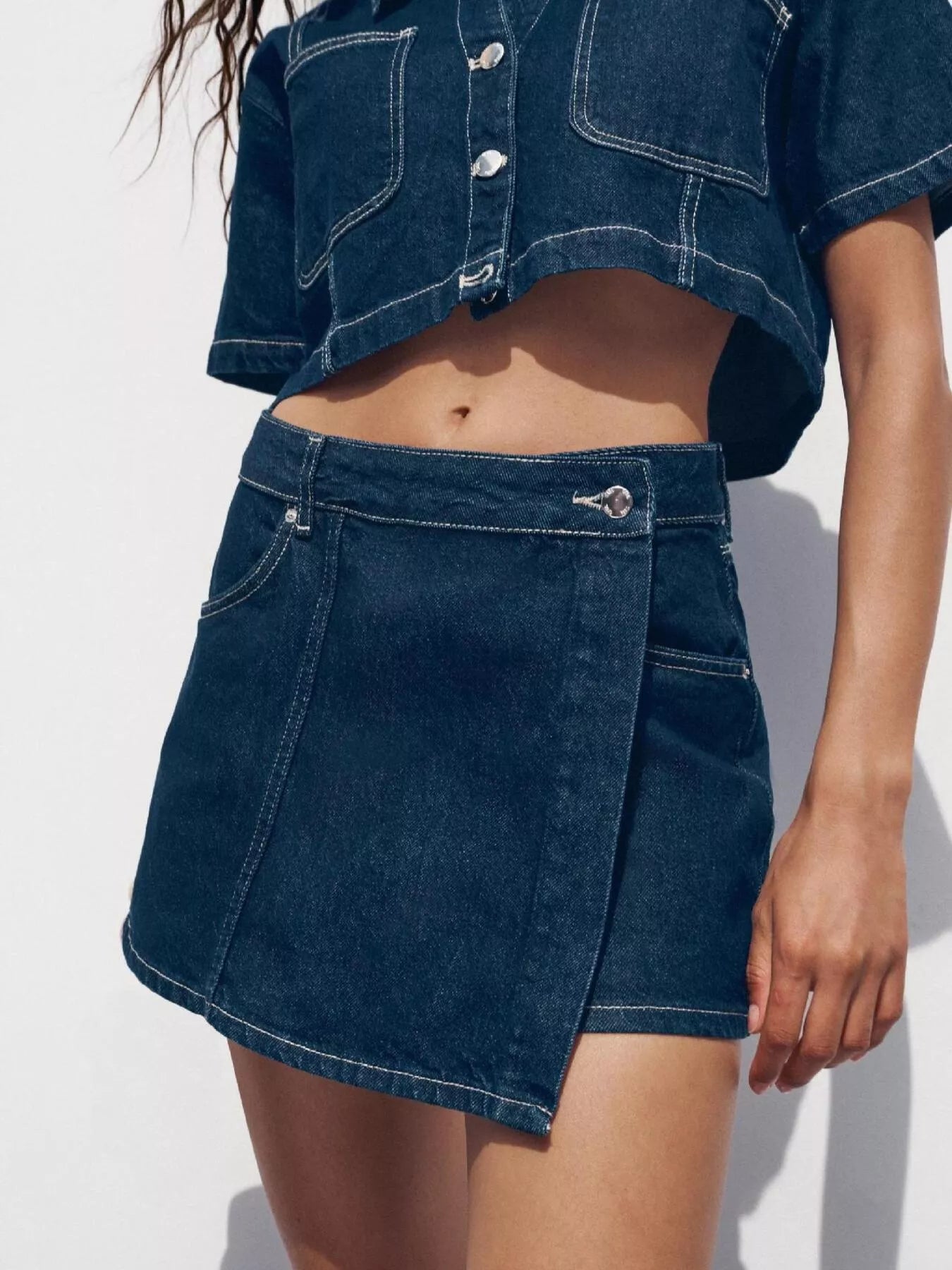 NEWYORKLISTED STYLE COLLECTION: Person wearing a blue denim skirt and jacket on a white background