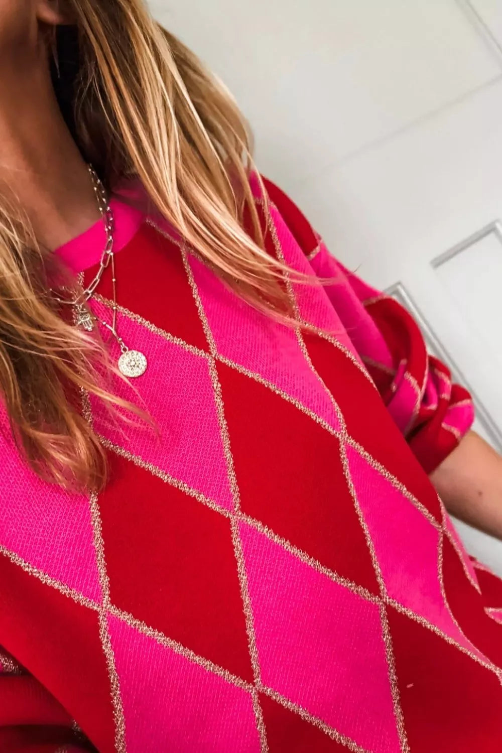 NEWYORKLISTED STYLE COLLECTION: Person wearing a bright pink and red patterned garment with a blurred background