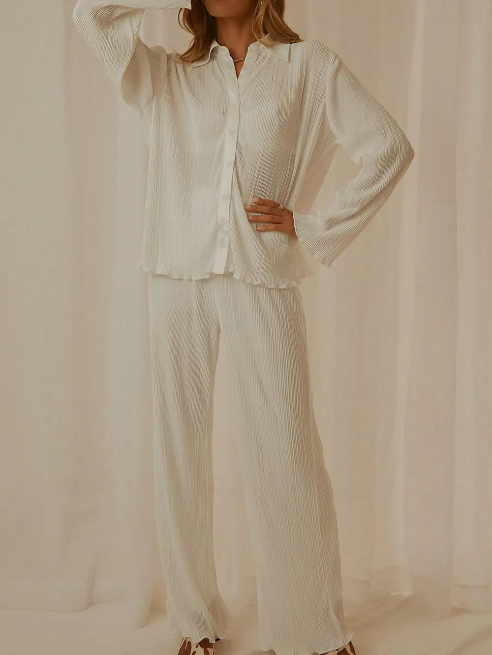 NEWYORKLISTED Intimate Apparel Collection: Person wearing a white textured shirt and pants against a beige background