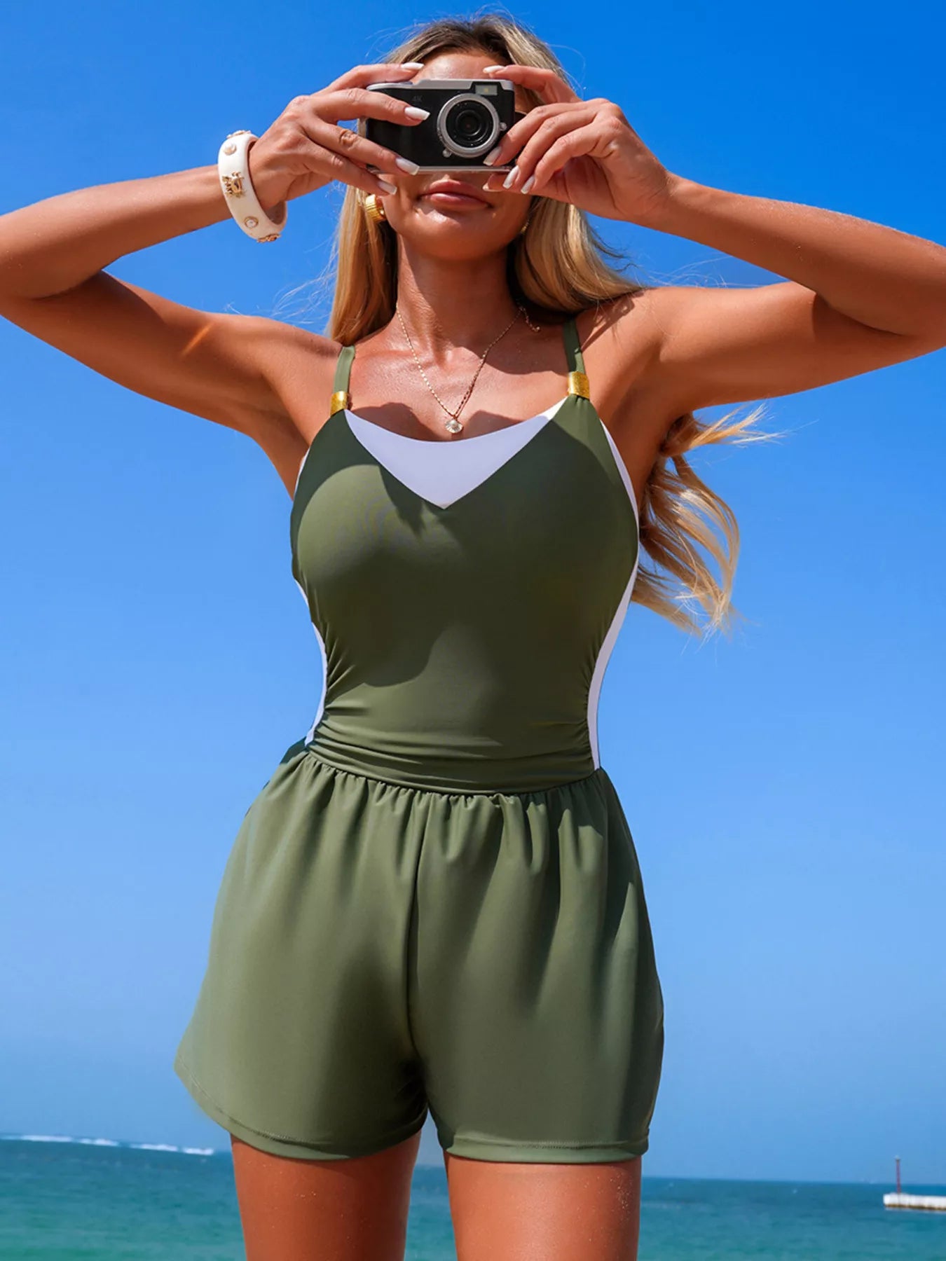 NEWYORKLISTED EDEN COLLECTION: Woman taking a selfie on a beach wearing an olive green romper.
