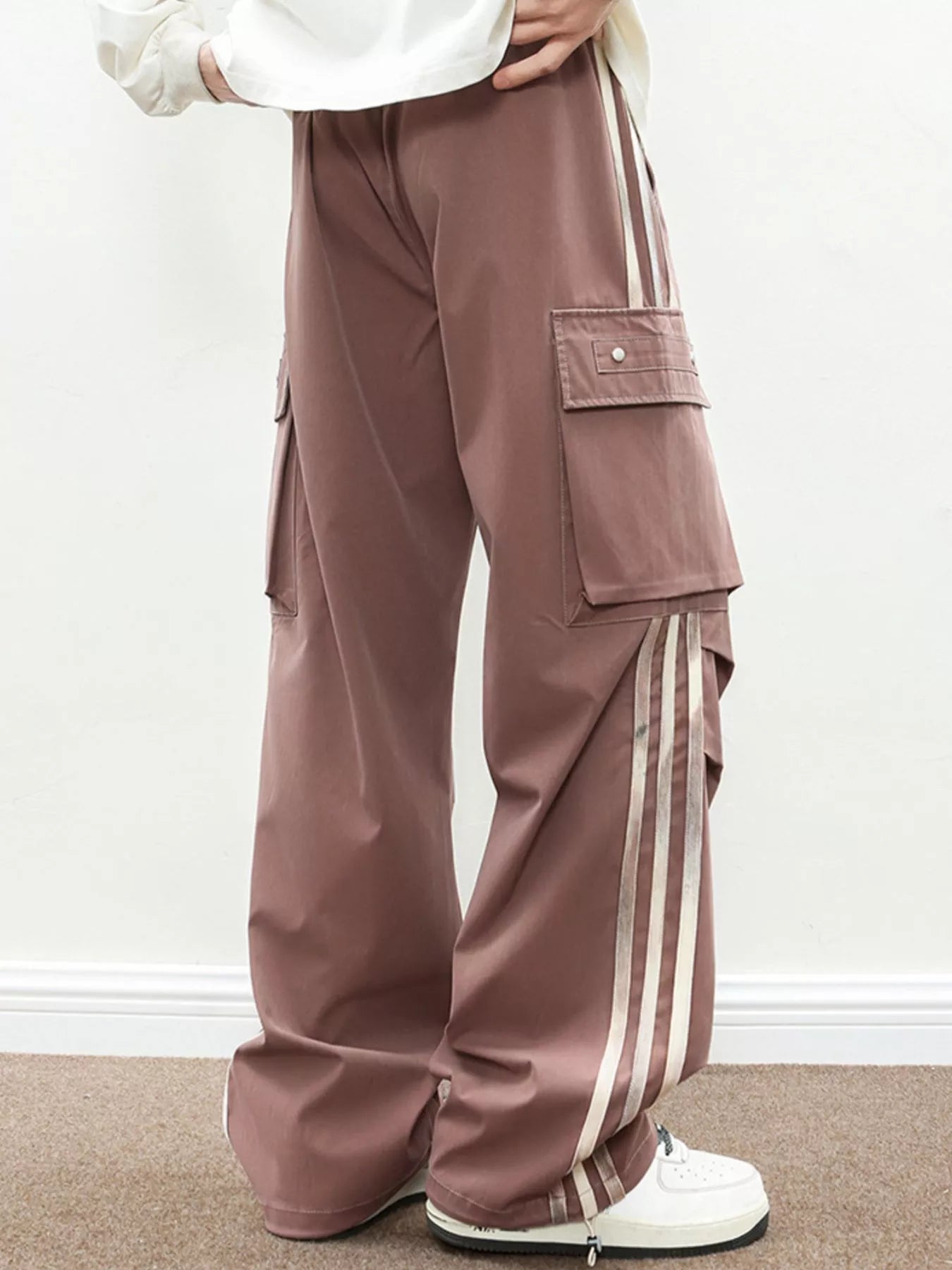 NEWYORKLISTED ATLAS MEN's COLLECTION: Brown cargo pants with white stripes worn by a person on a plain background