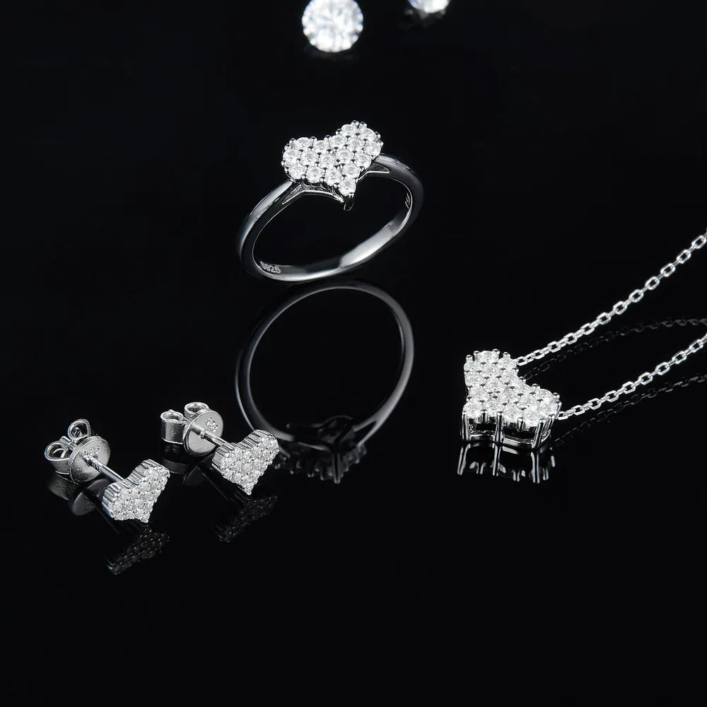 NYLD Glamour Collection By NEWYORKLISTED: Silver jewelry set including earrings, a ring, and a necklace on a black background