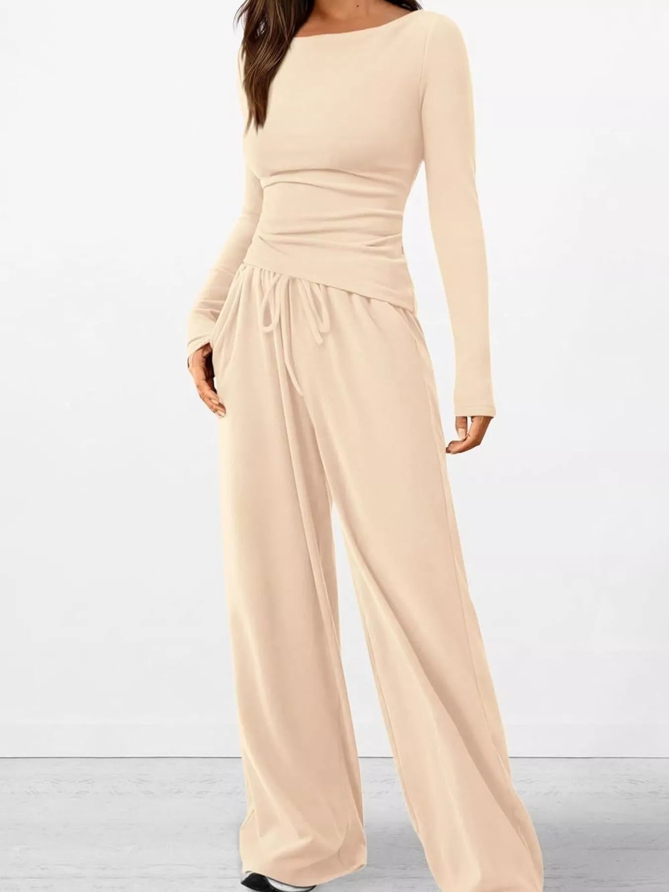 Beige jumpsuit with long sleeves on a white background