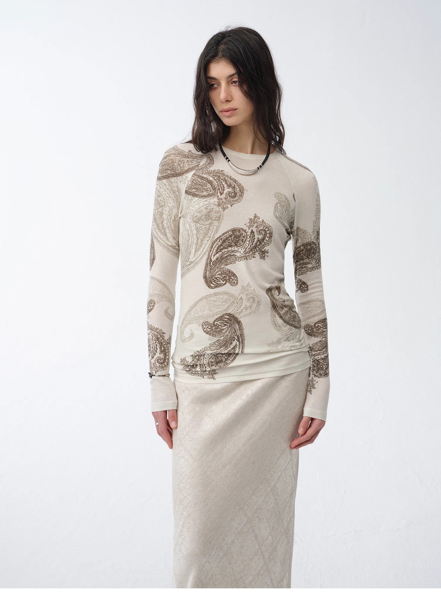 Woman wearing a long-sleeve top with a pattern on a white background