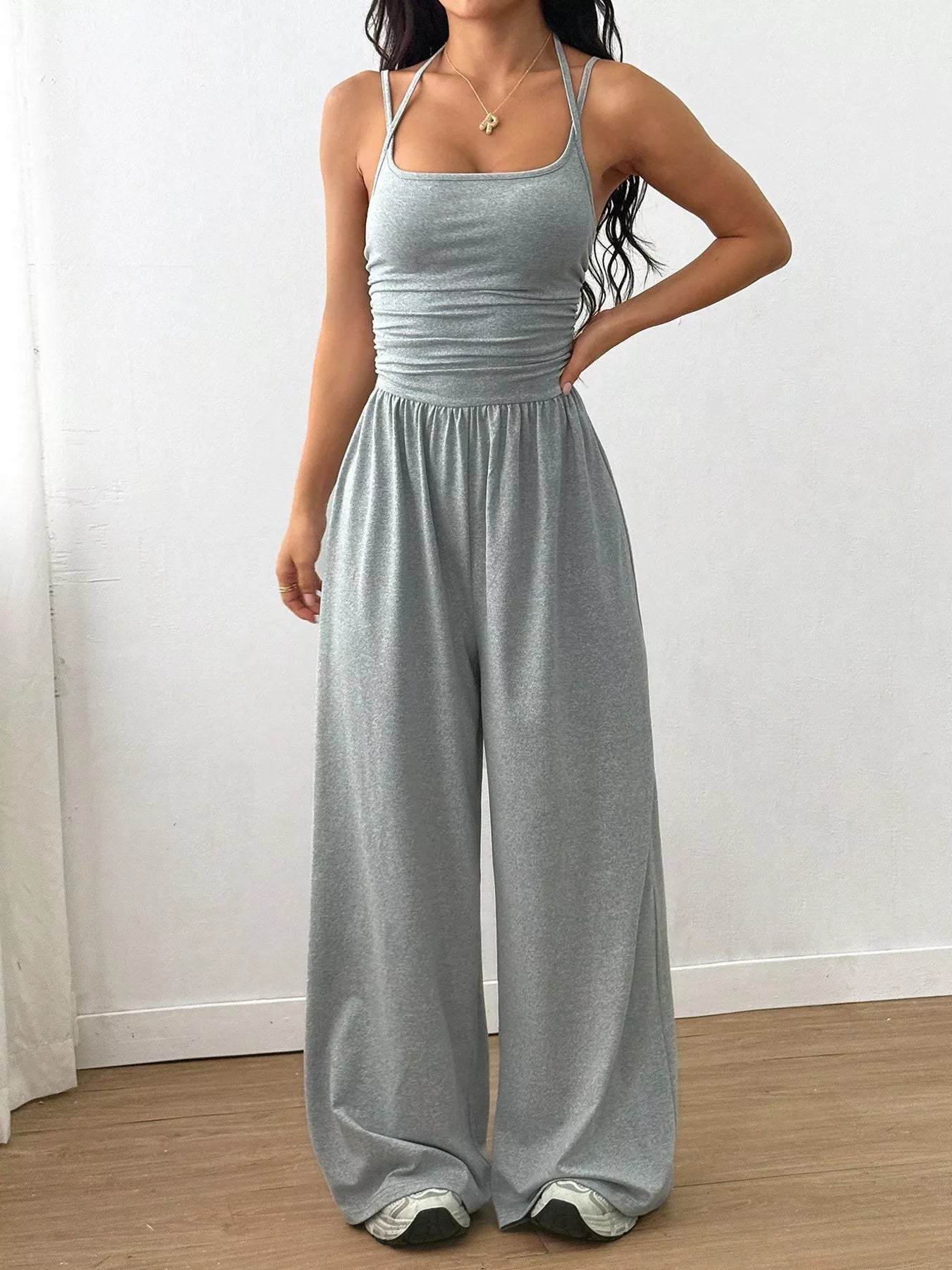 NEWYORKLISTED Comfort Collection: Woman wearing a gray jumpsuit against a white background