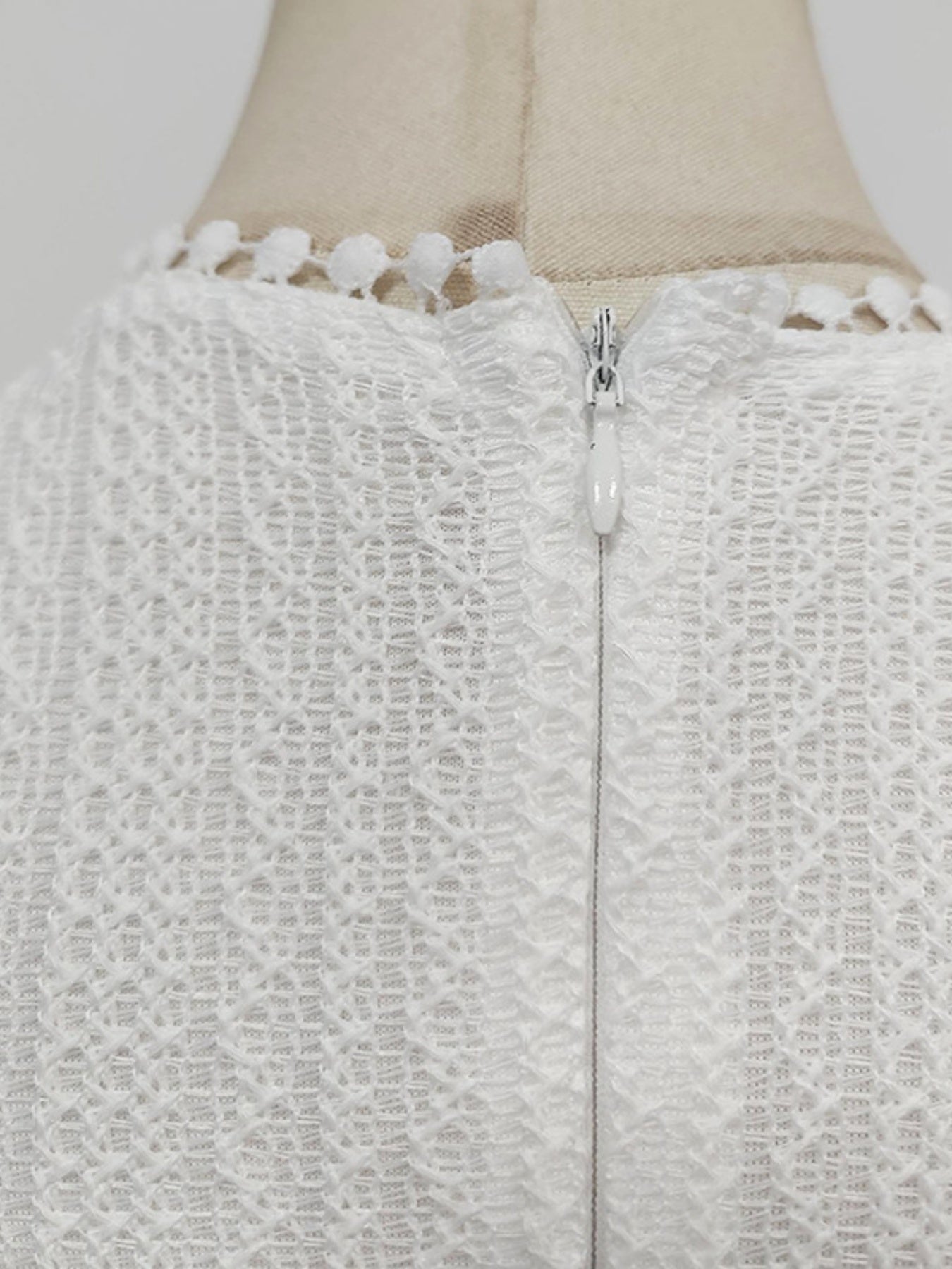 NEWYORKLISTED STYLE COLLECTION: Close-up of a textured white garment with a zipper on a mannequin.