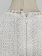 NEWYORKLISTED STYLE COLLECTION: Close-up of a textured white garment with a zipper on a mannequin.
