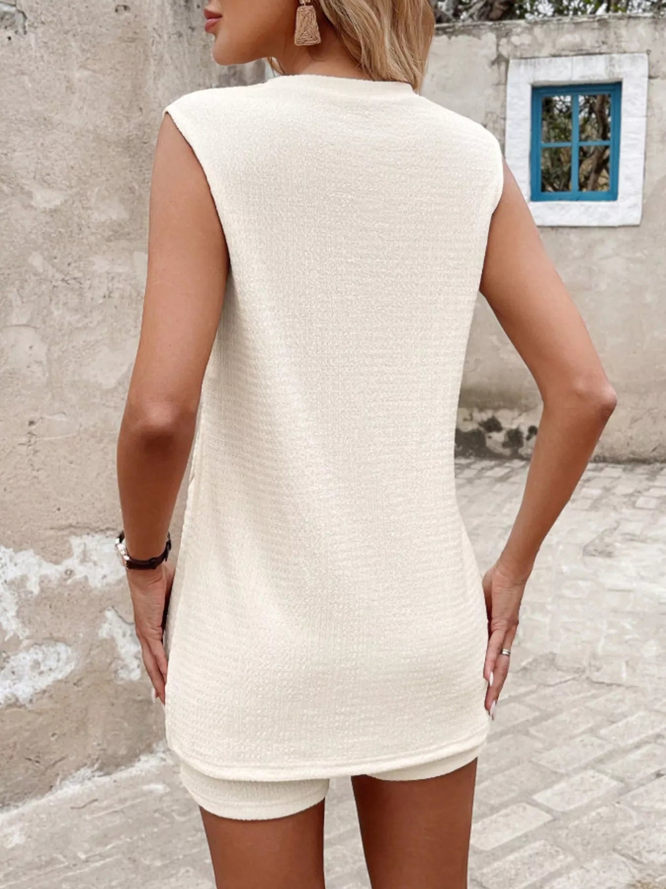 NEWYORKLISTED STYLE COLLECTION: Woman wearing a white sleeveless dress in an outdoor setting.