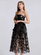 NEWYORKLISTED STYLE COLLECTION: Black lace strapless dress worn by a model on a white background